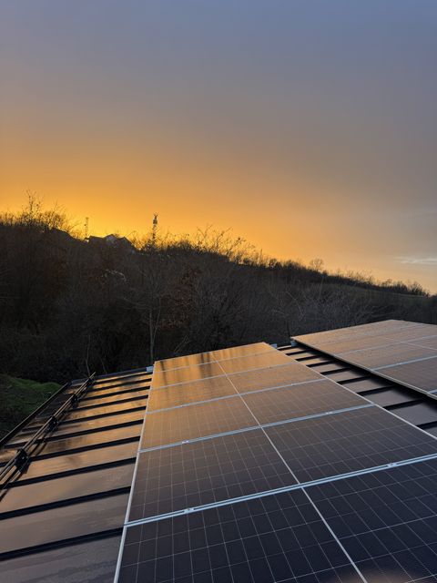 Solarni paneli na limenom krovu u zalasku sunca